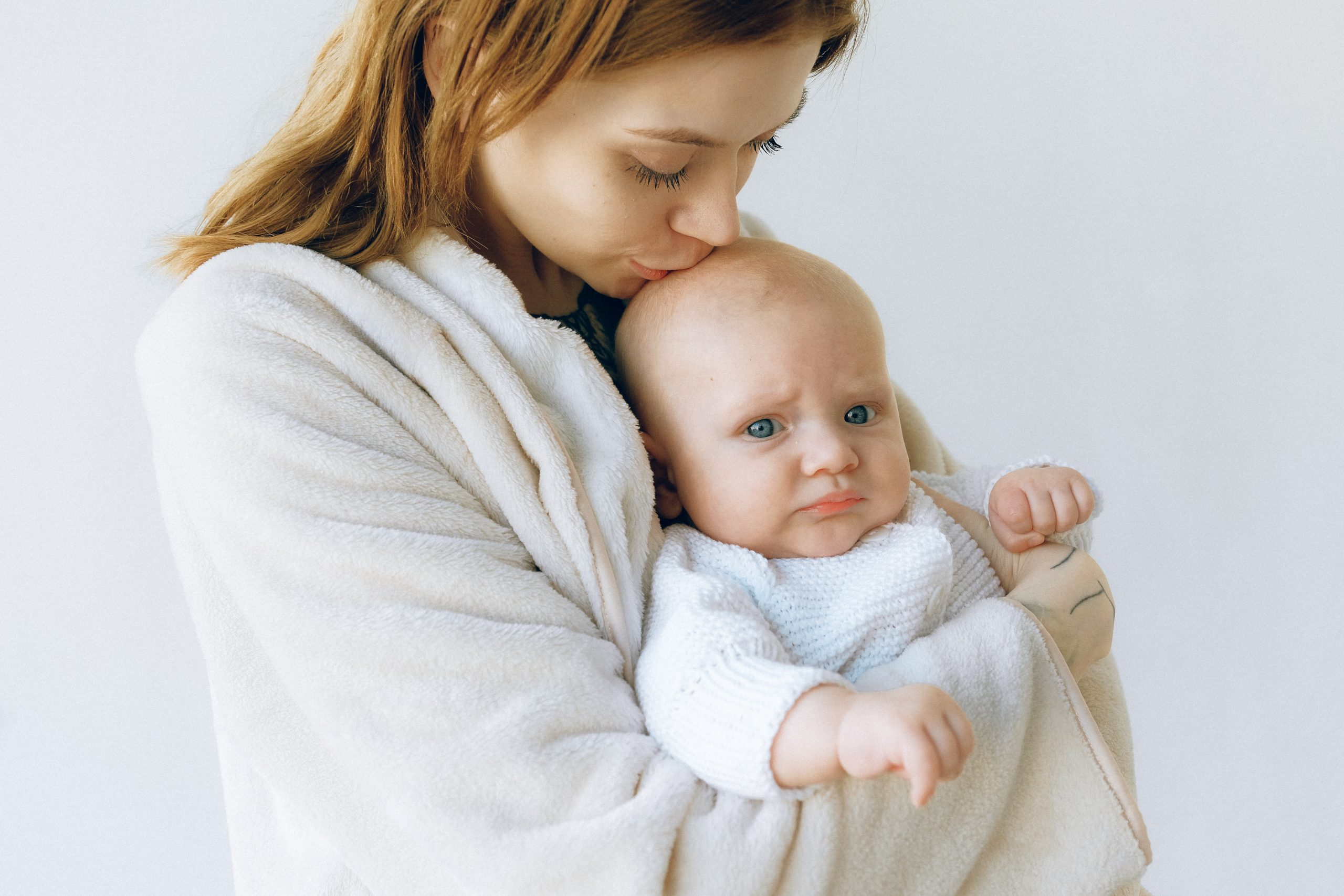 Kobieta trzymająca dziecko z kolką niemowlęcą.