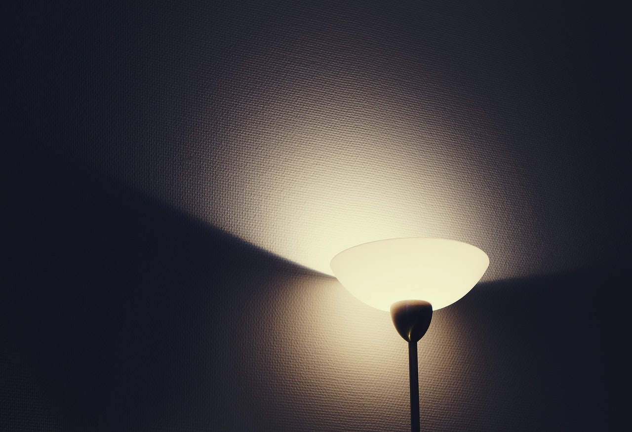 Ciemna lampa podłogowa stroi w kącie pokoju