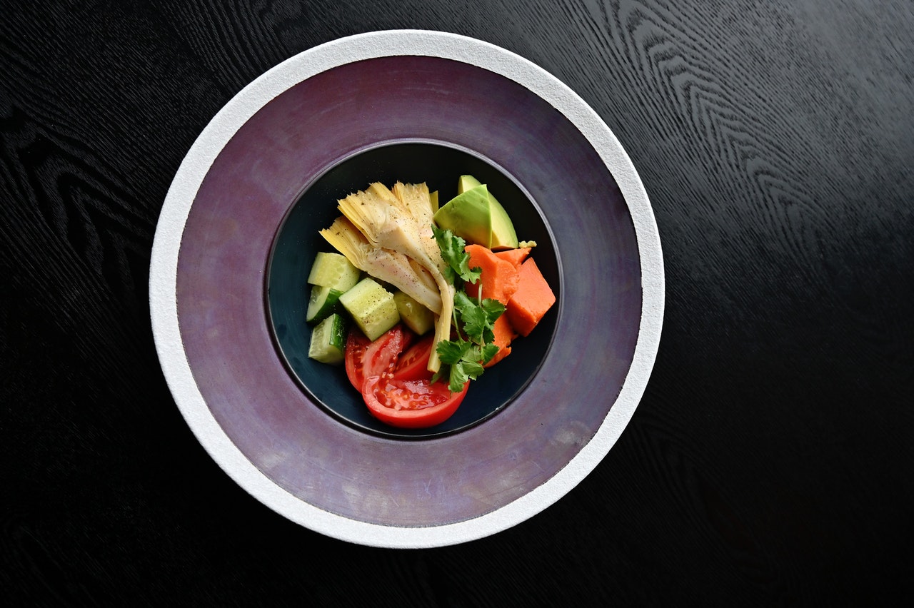 Zdrowy posiłęk pełen warzyw na talerzu który lezy na stole