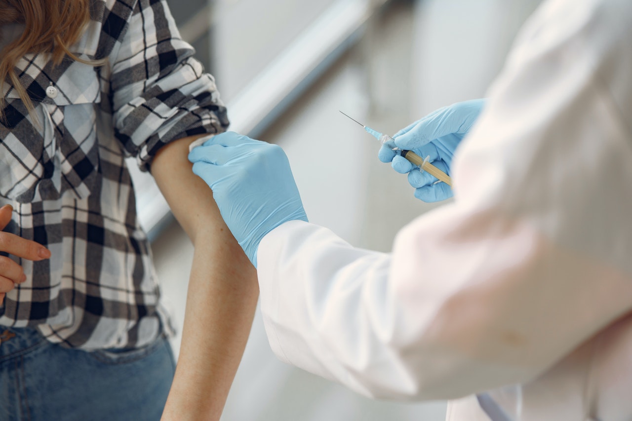 Pielęganiarka podaje szczepionke kobiecie przeciw HPV