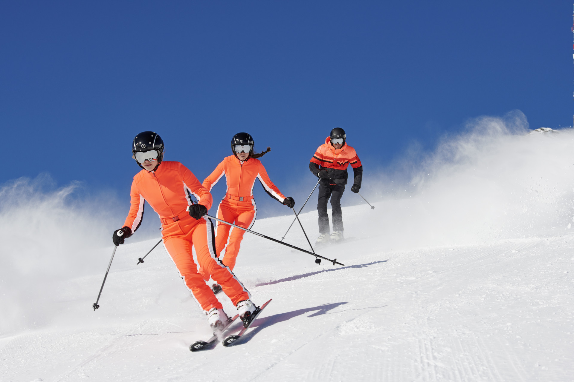 Kilka osób zjeżdza na nartach z góry
