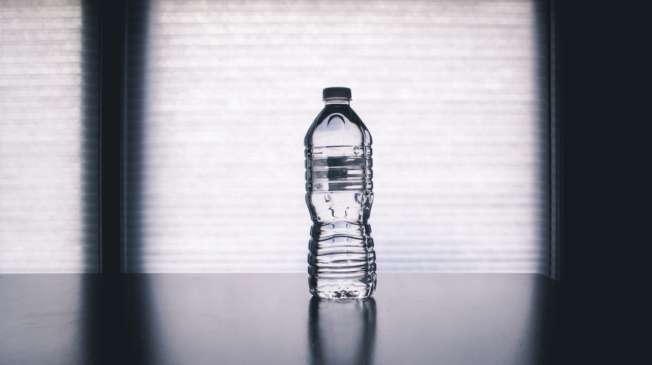 Plastikowa butelka stoi na stole
